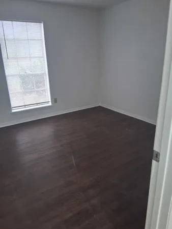 a view of a small space with wooden floor and a window