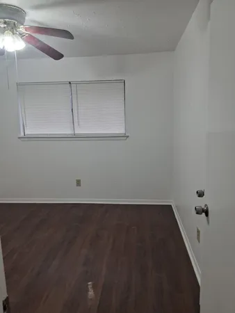 a view of a room with wooden floor and fan