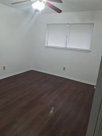 an empty room with wooden floor and cabinet