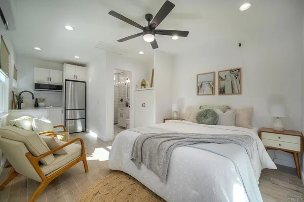 a spacious bedroom with a bed couch and a window