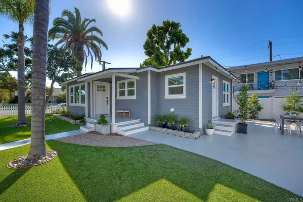 a front view of a house with a garden and plants