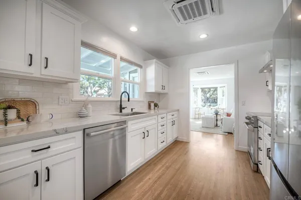 a kitchen with sink stove refrigerator and cabinets