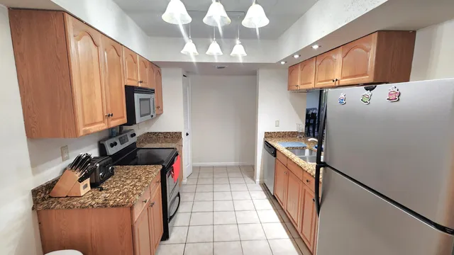 a kitchen with a refrigerator a stove top oven a sink and dishwasher