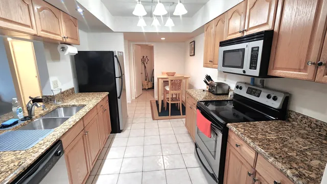 a kitchen with a sink stove top oven and refrigerator
