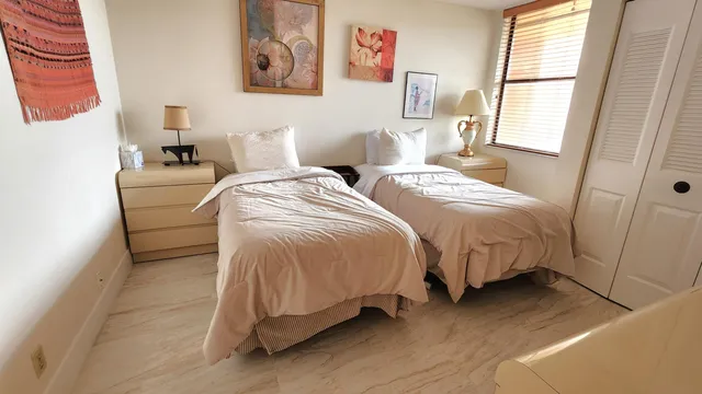 a bedroom with two beds and a window