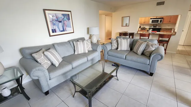 a living room with furniture a rug and a wall painting