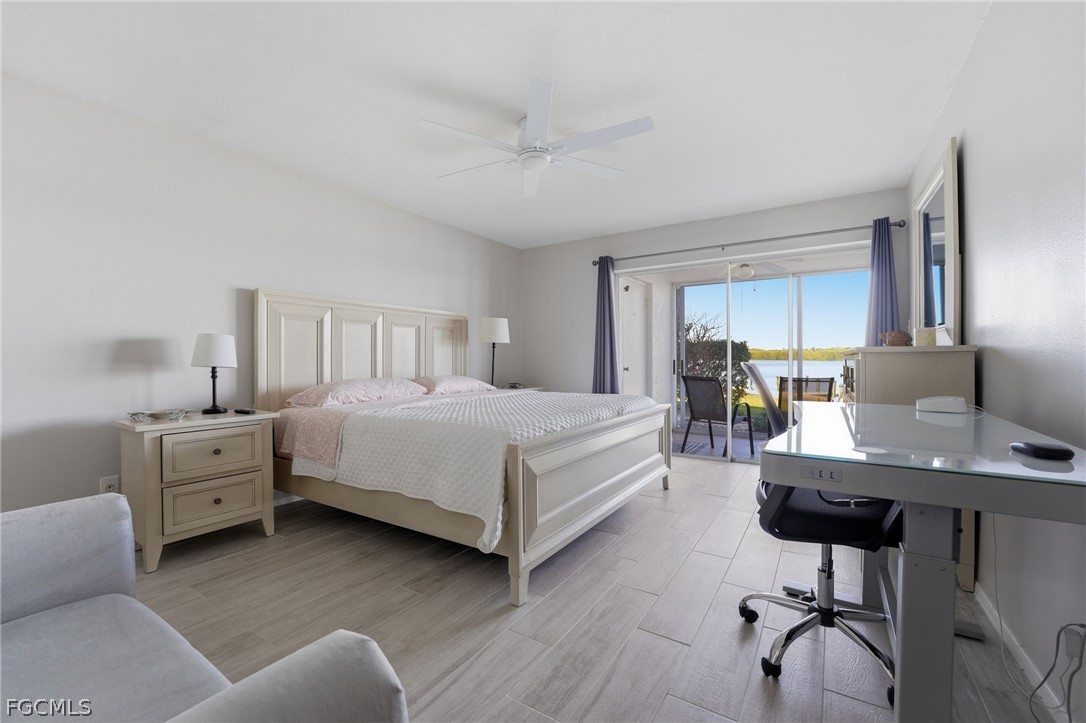 4440 Exeter Drive Longboat Key, FL 34228 - Photo 10 of 24 a bedroom with a bed window table chair and glass door