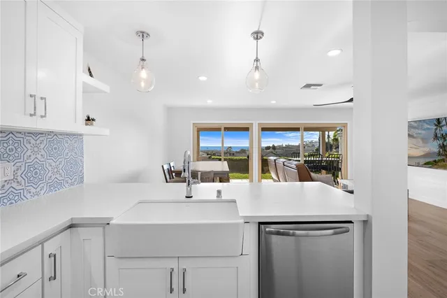 a view of a kitchen with granite countertop a sink and cabinets