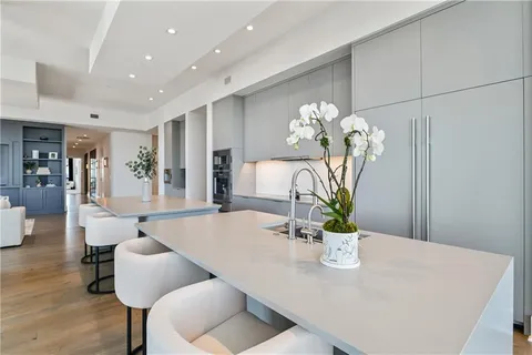 a large kitchen with stainless steel appliances a large counter top a stove and a refrigerator