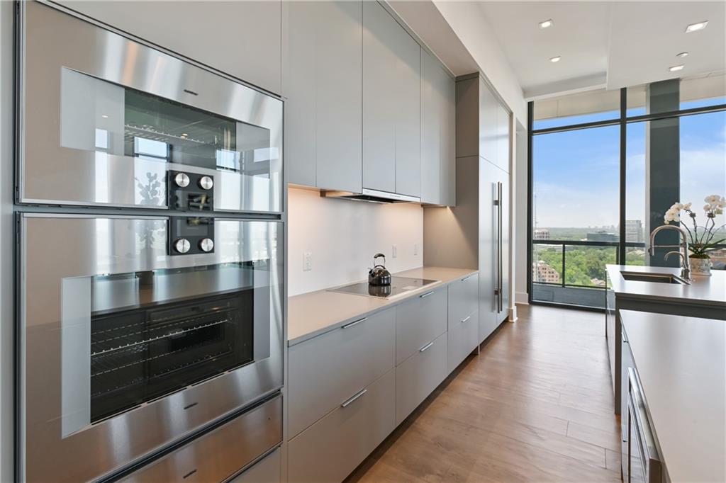 3107 Peachtree Road Northeast, Unit 2003 Atlanta, GA 30305 - Photo 22 of 114 a large kitchen with stainless steel appliances a large counter top a stove and a refrigerator