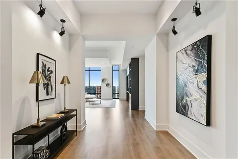 a living room with couches and kitchen view with wooden floor