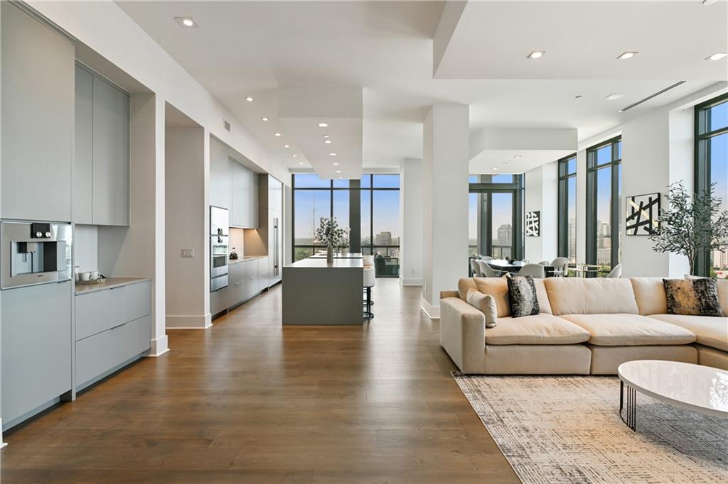 3107 Peachtree Road Northeast, Unit 2003 Atlanta, GA 30305 - Photo 6 of 114 a living room with couches and kitchen view with wooden floor