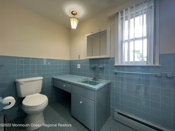 a bathroom with a toilet sink and mirror