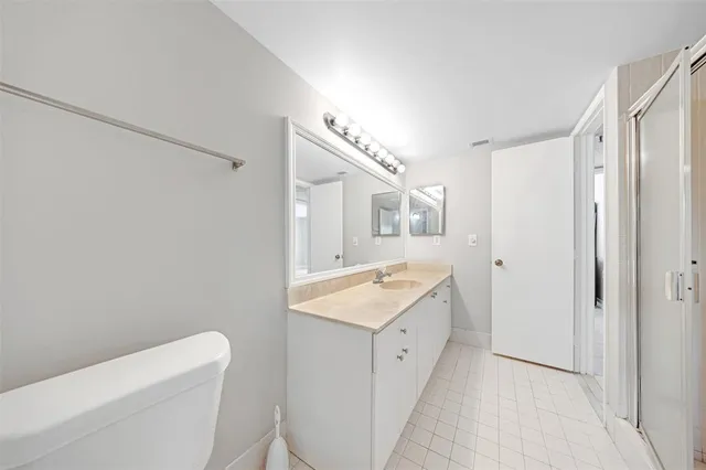 a bathroom with a granite countertop sink mirror vanity and toilet