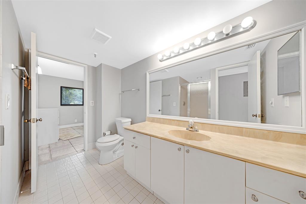 2202 South Cypress Bend Drive, Unit 207 Pompano Beach, FL 33069 - Photo 15 of 20 a spacious bathroom with a granite countertop sink a toilet and a mirror