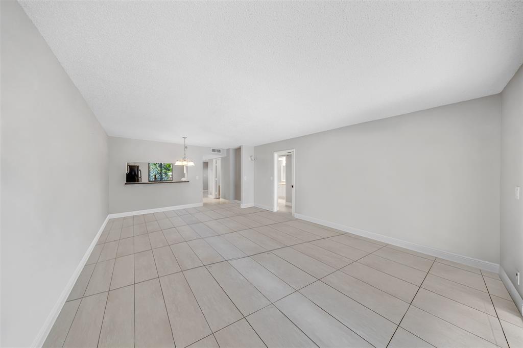 2202 South Cypress Bend Drive, Unit 207 Pompano Beach, FL 33069 - Photo 7 of 20 a view of a livingroom with an empty space and a window