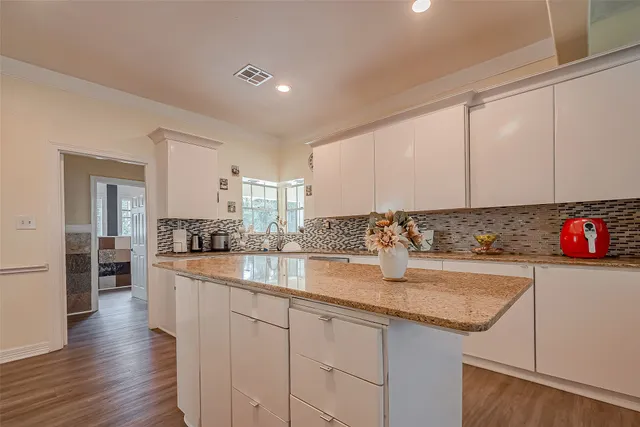 a kitchen with granite countertop a sink and cabinets