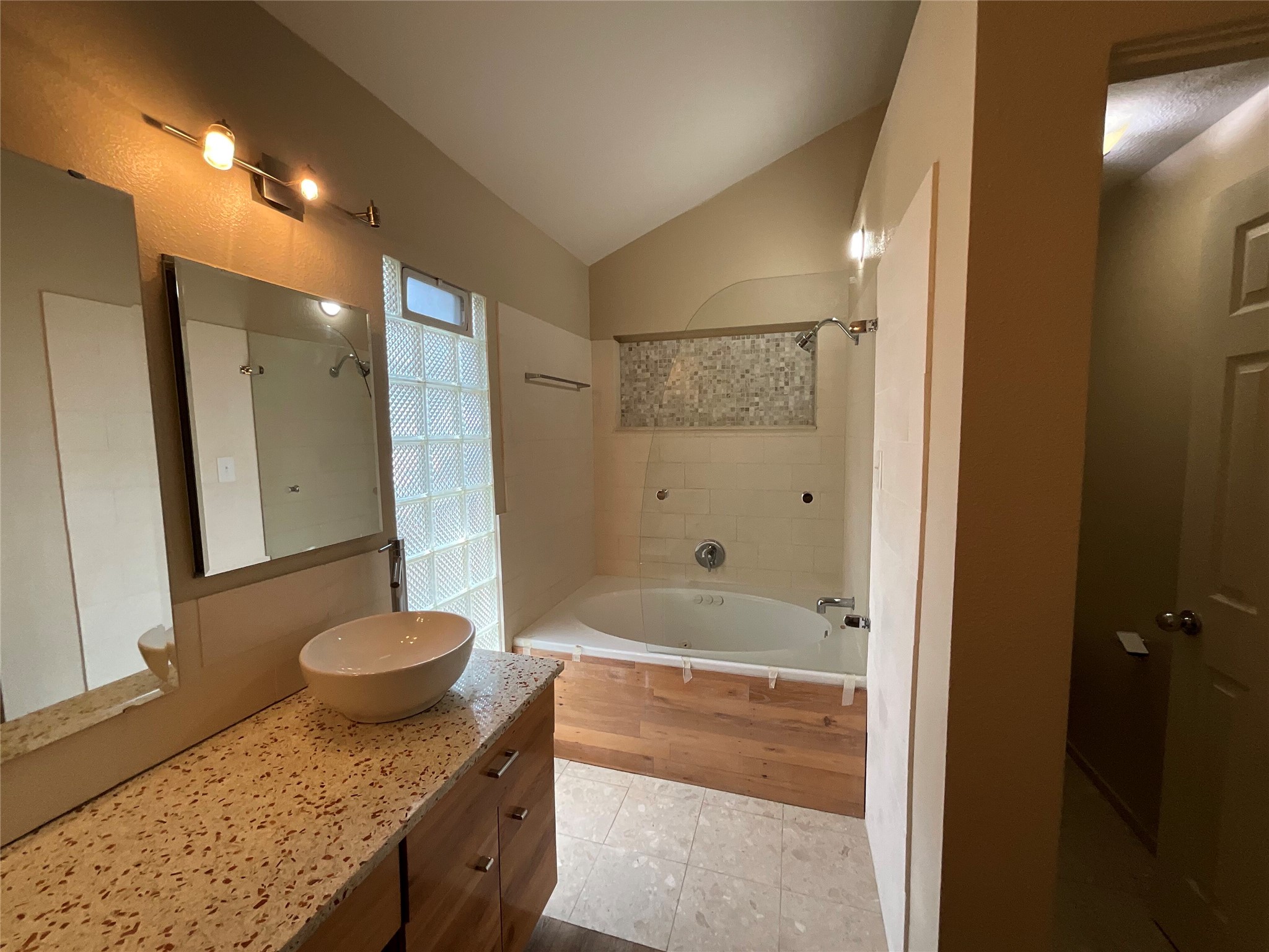 15702 Racine Cove Austin, TX 78717 - Photo 22 of 27 A well-appointed bathroom features a deep soaking tub and a unique vessel sink.