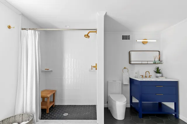 a bathroom with a toilet a sink and mirror