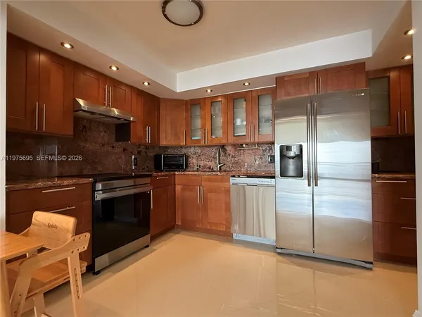 a kitchen with a refrigerator and a stove top oven
