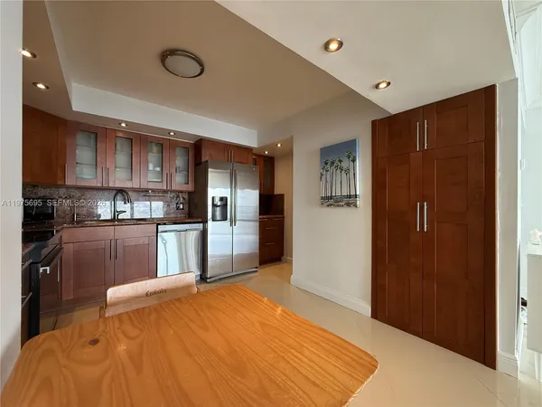 a large kitchen with stainless steel appliances granite countertop a refrigerator and a sink