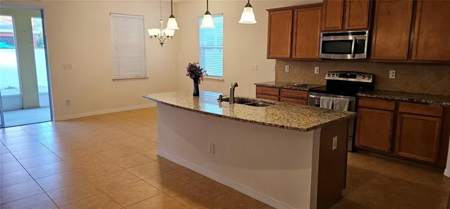 a kitchen with granite countertop a sink a stove and cabinets