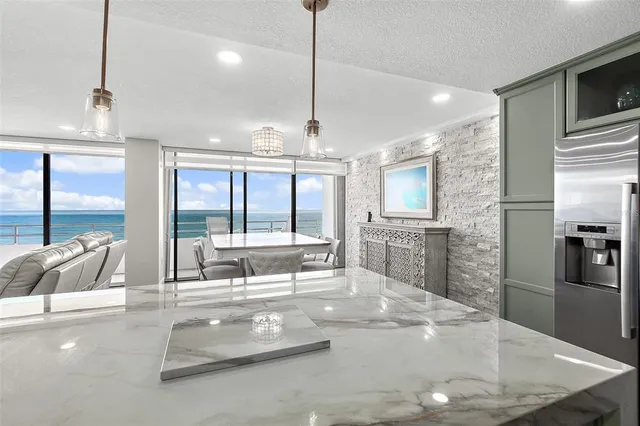 a living room with stainless steel appliances kitchen island granite countertop furniture and a large window