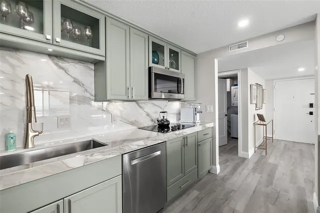 a kitchen with stainless steel appliances granite countertop a sink stove and refrigerator