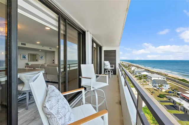 a living room with dining table a rug and kitchen view