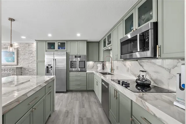 a kitchen with stainless steel appliances granite countertop a sink stove and refrigerator