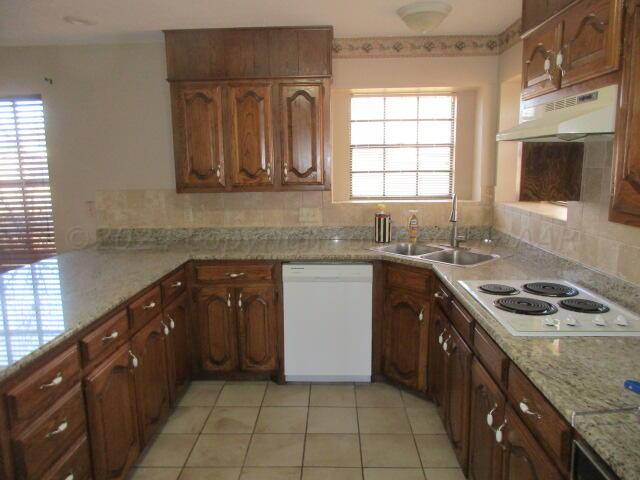 a kitchen with a sink stove top oven and cabinets