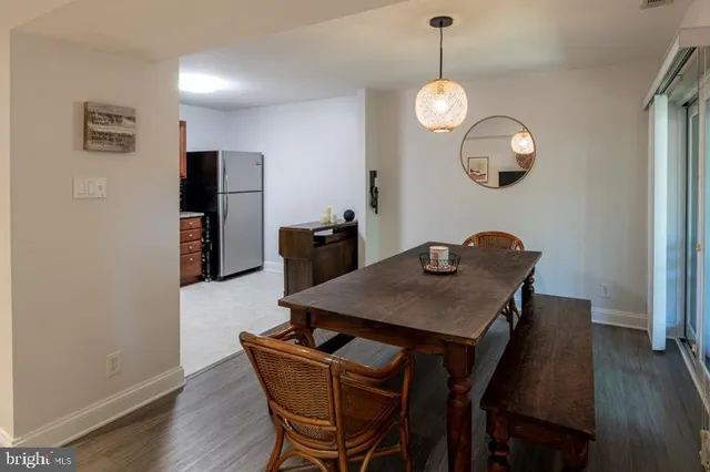 a dining room with wooden floor a chandelier a wooden table and chairs