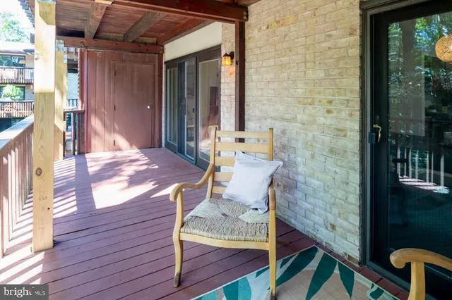 a patio view with a wooden bench and floor