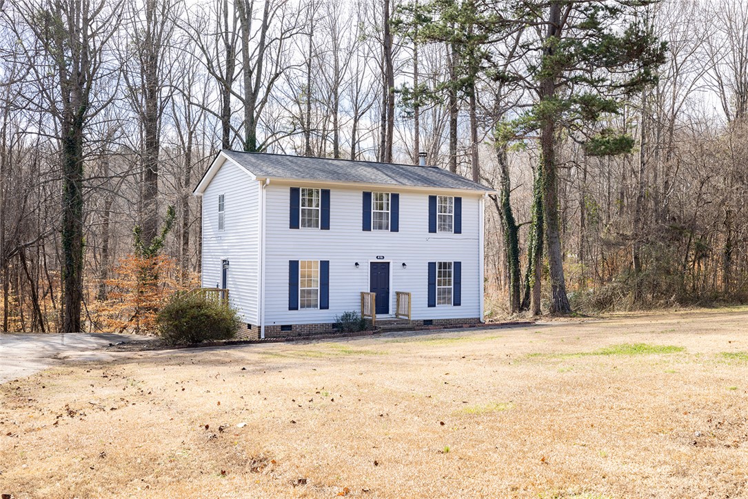 This charming home offers a serene escape, nestled among mature trees on a spacious lot.