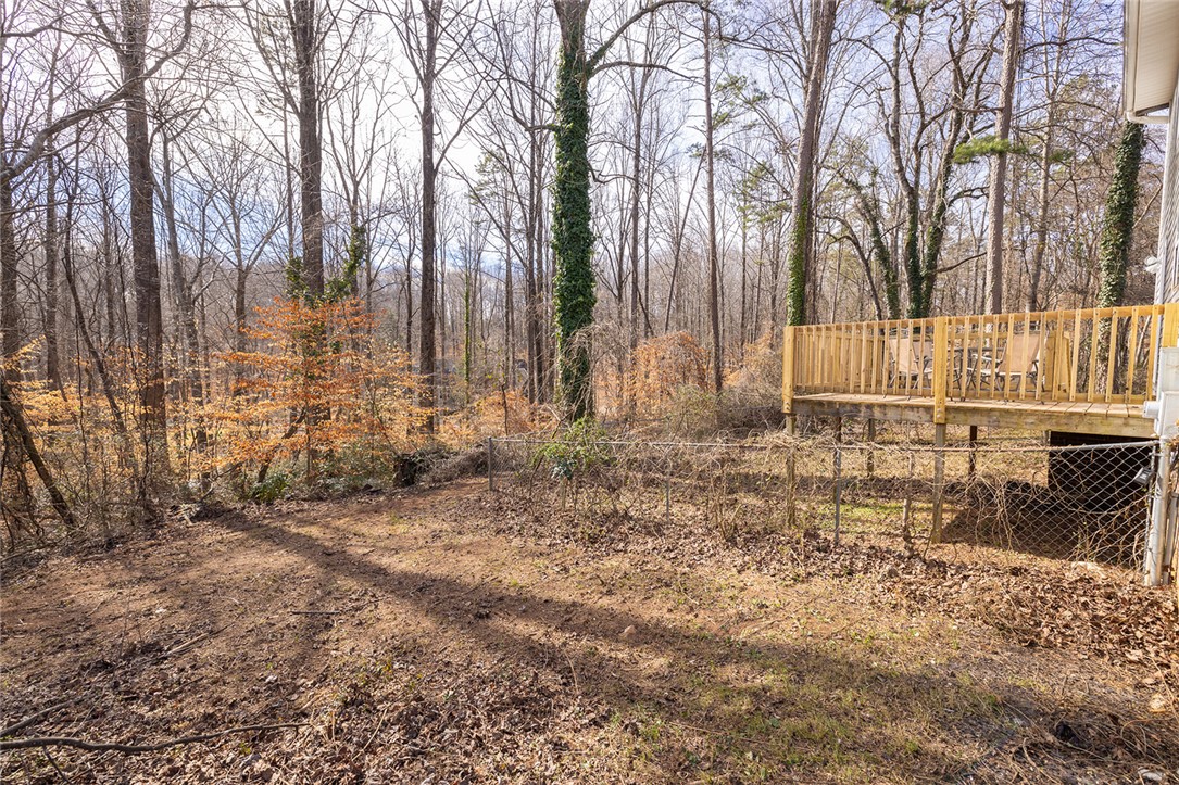 410 South Cove Road Seneca, SC 29672 - Photo 15 of 25 This peaceful backyard offers a tranquil retreat with a private wooden deck and lush natural surroundings.