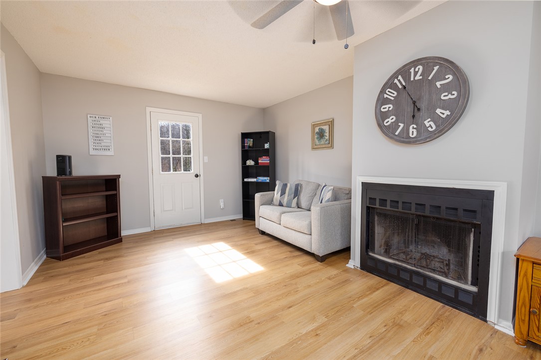 410 South Cove Road Seneca, SC 29672 - Photo 10 of 25 This bright living space features warm flooring, a cozy fireplace, and an inviting entry door.