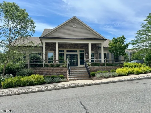 a front view of a house with a yard and potted plants