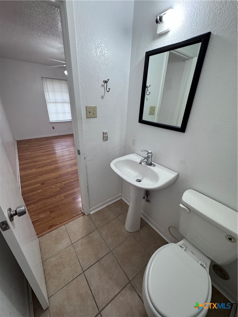 1301 North 10th Street Temple, TX 76501 - Photo 17 of 25 a bathroom with a toilet a sink and mirror