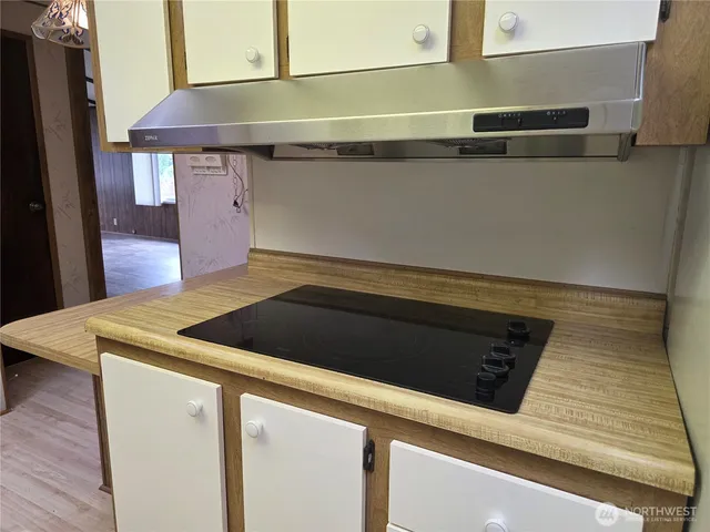 a kitchen with stainless steel appliances granite countertop a sink a stove and a wooden floors