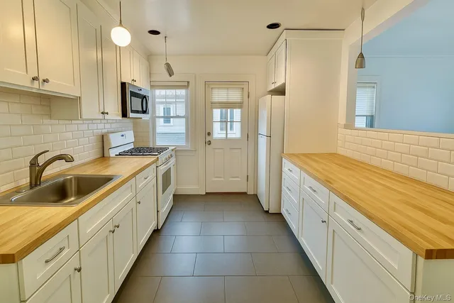 a kitchen with granite countertop a sink and cabinets