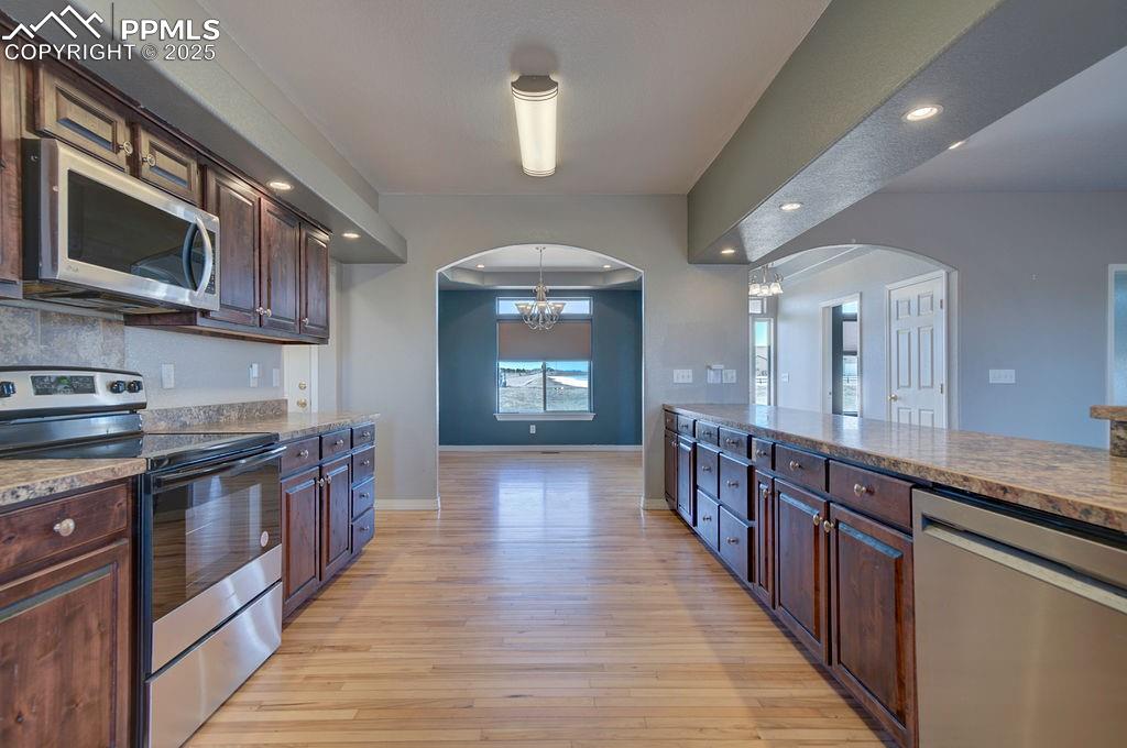 10935 McKissick Road Peyton, CO 80831 - Photo 17 of 50 a kitchen with stainless steel appliances granite countertop a stove a sink and a microwave