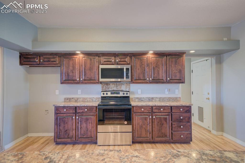 10935 McKissick Road Peyton, CO 80831 - Photo 18 of 50 a kitchen with stainless steel appliances granite countertop a stove and a sink