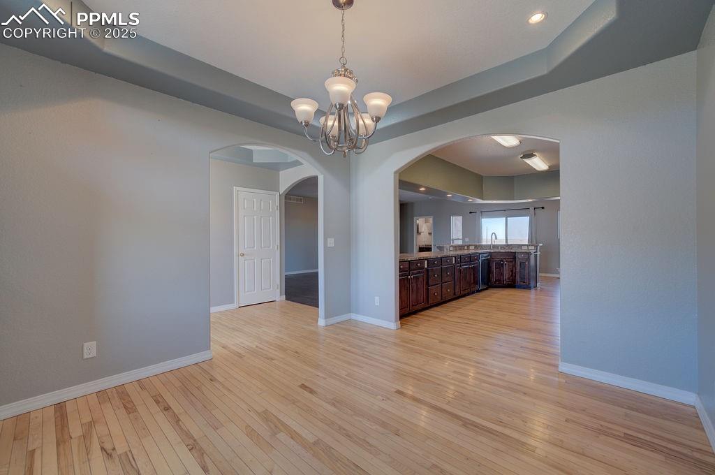 10935 McKissick Road Peyton, CO 80831 - Photo 22 of 50 a view of an empty room with wooden floor and a kitchen