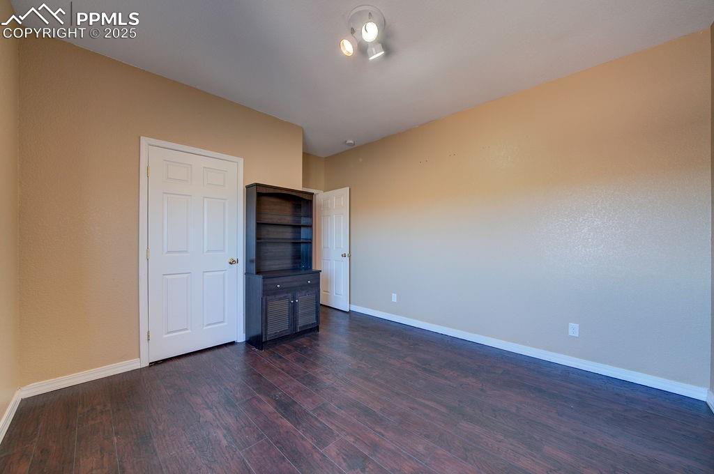 10935 McKissick Road Peyton, CO 80831 - Photo 35 of 50 a view of an empty room with a kitchen and wooden floor