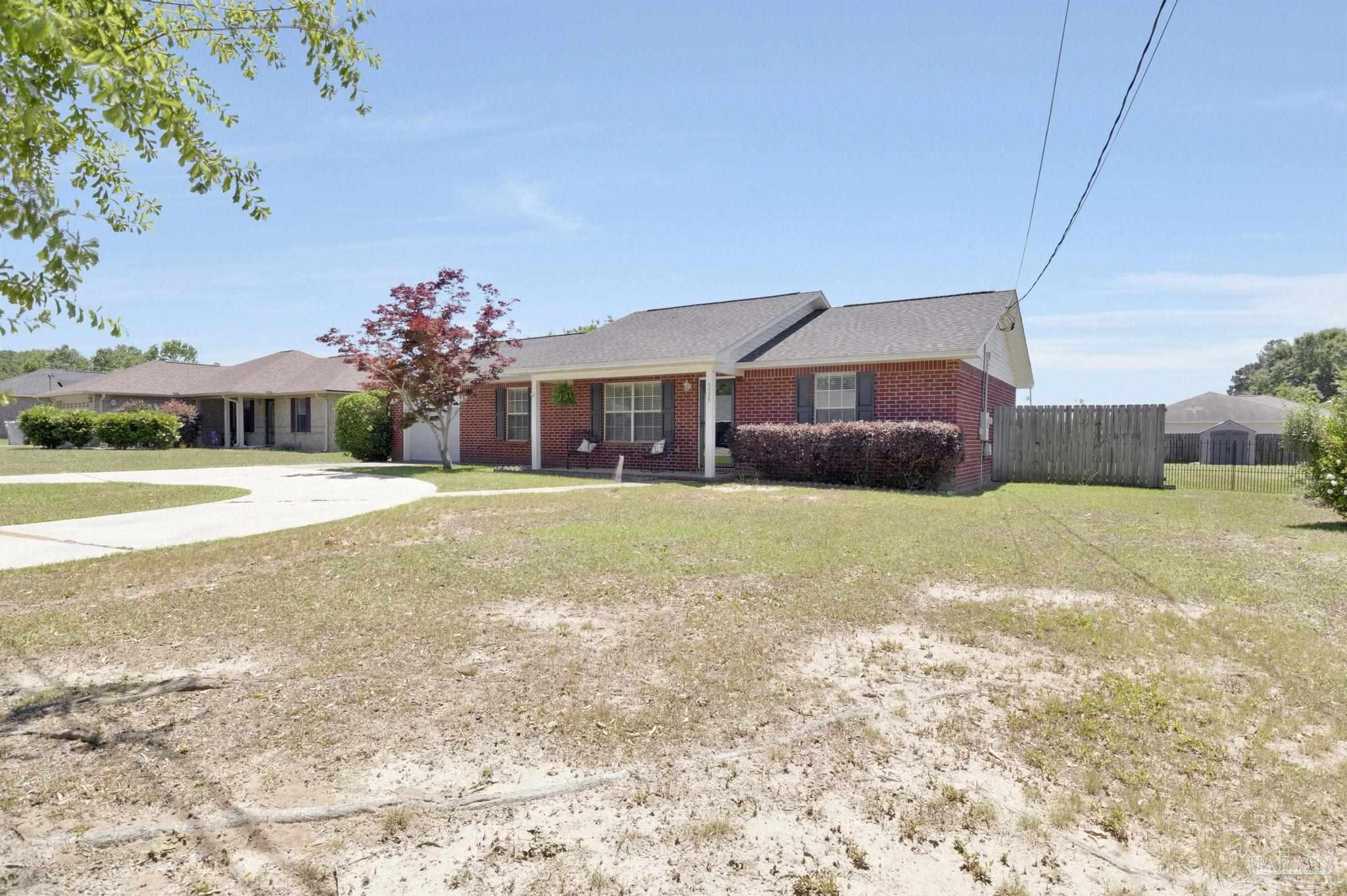 5539 Windrun Place Pace, FL 32571 - Photo 53 of 62 a front view of house with yard and trees in the background