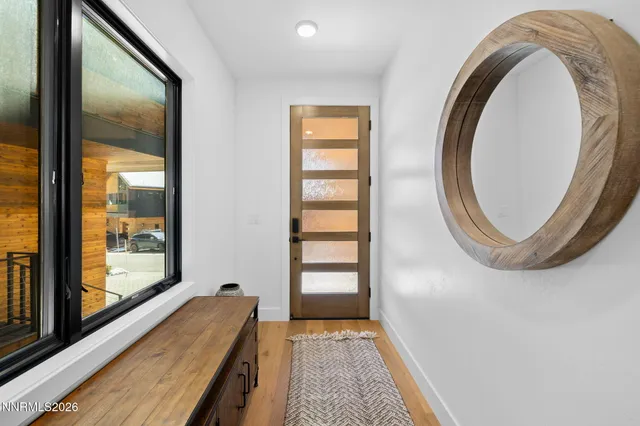 a view of a bedroom with wooden floor and windows