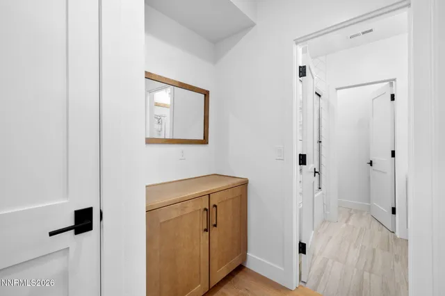 a view of bathroom with a sink mirror and window