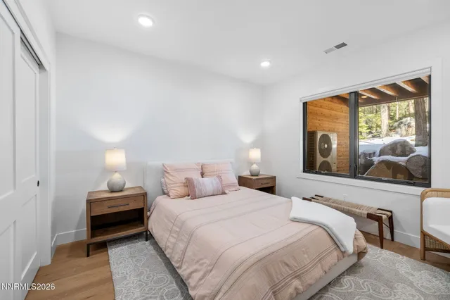 a bedroom with a bed and wooden floor