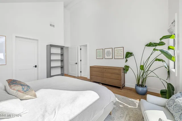 a bedroom with a bed and a dresser next to a window