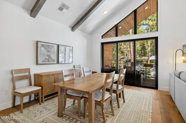 a dining room with furniture a rug and wooden floor